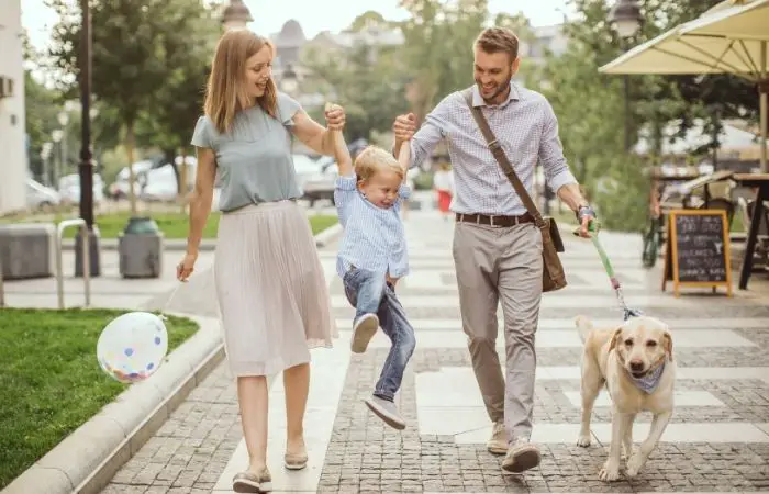 Family walking with his dog on the pavement